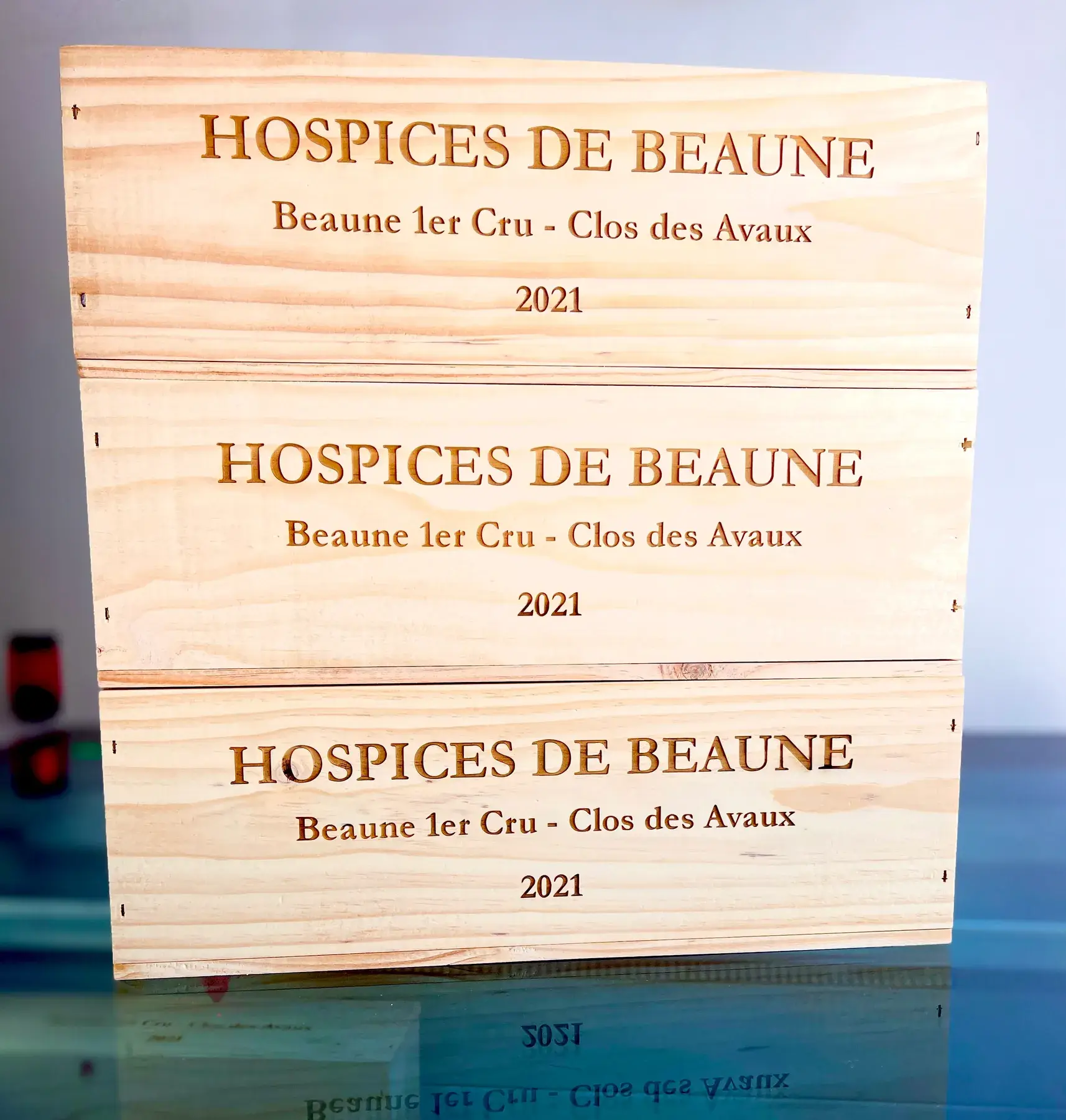 Série de caisses en bois gravées empilées dans l’atelier