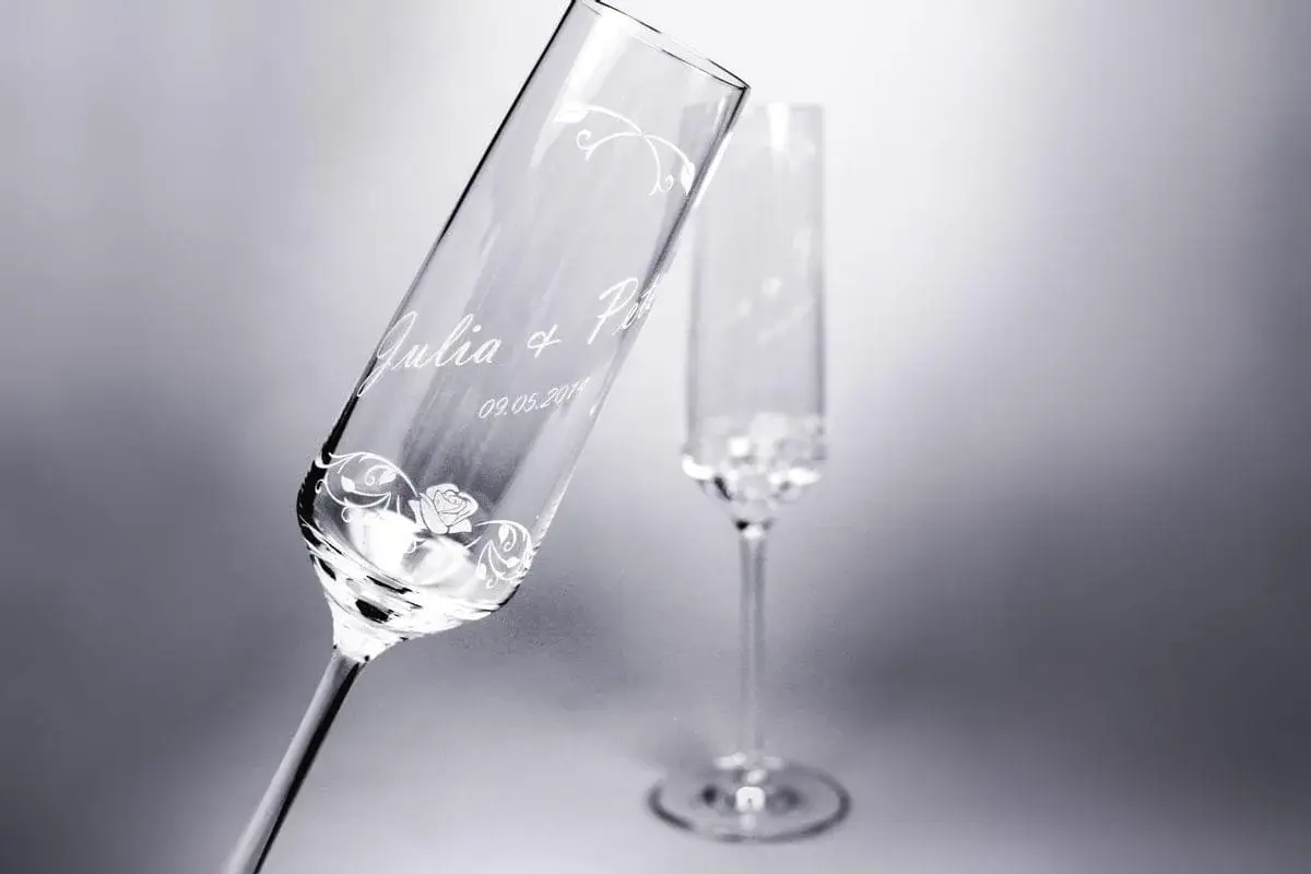 Deux flûtes à champagne gravées avec des prénoms, une date et un décor floral fin